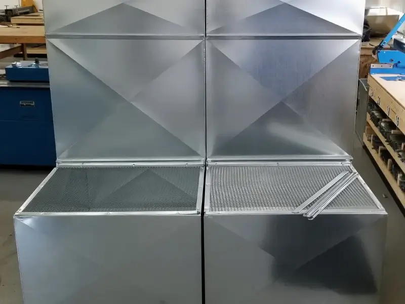 Metallic ceiling panels with geometric patterns and a vent.