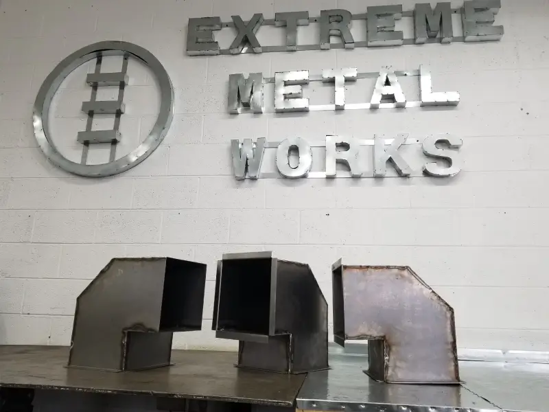 Metal pieces arranged under a sign reading 'Extreme Metal Works'.